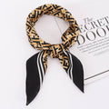 Patterned scarf with black and gold design on a white surface