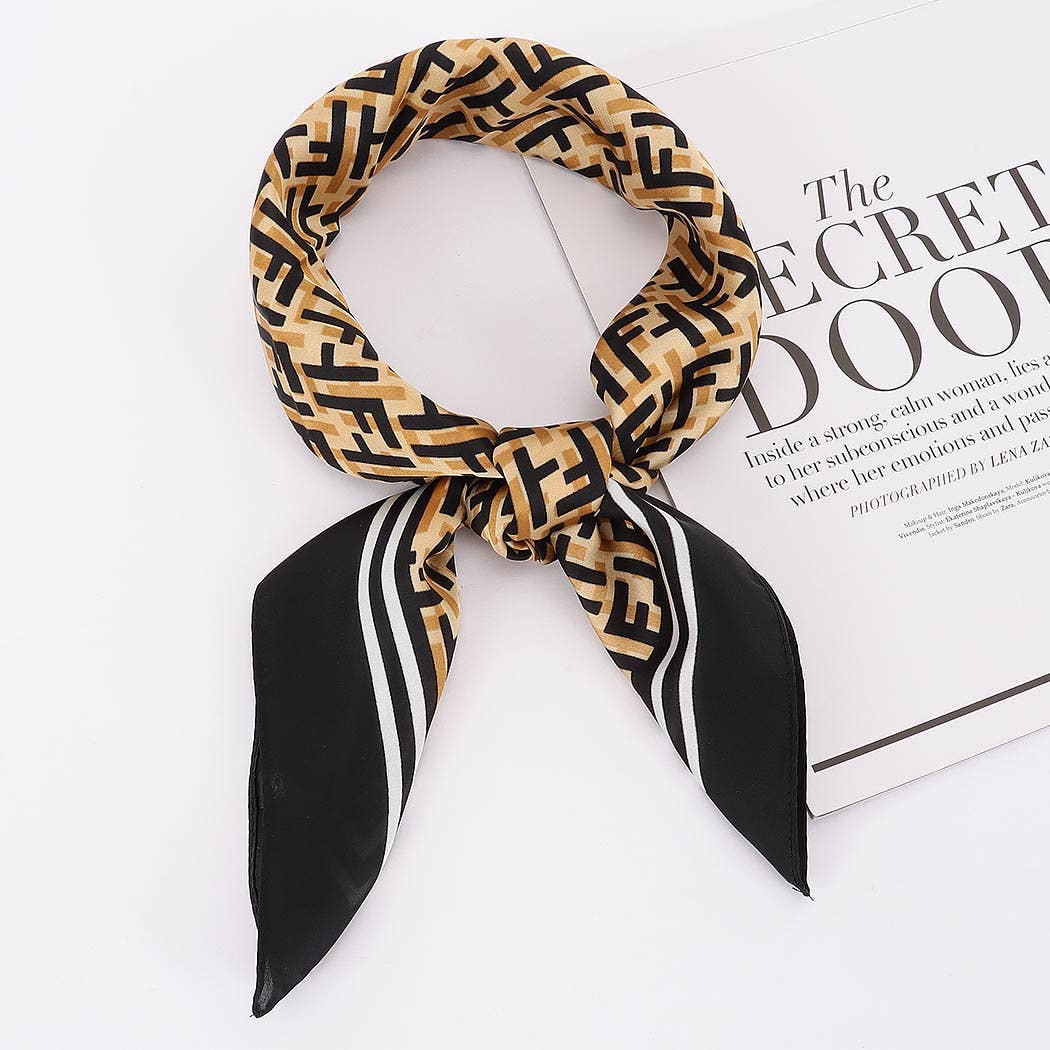 Patterned scarf with black and gold design on a white surface